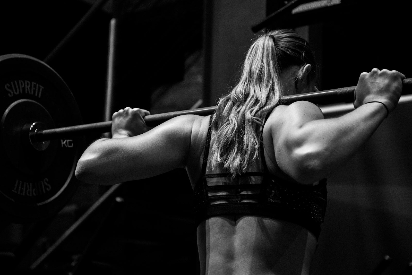 A coach spotting a client through a back squat